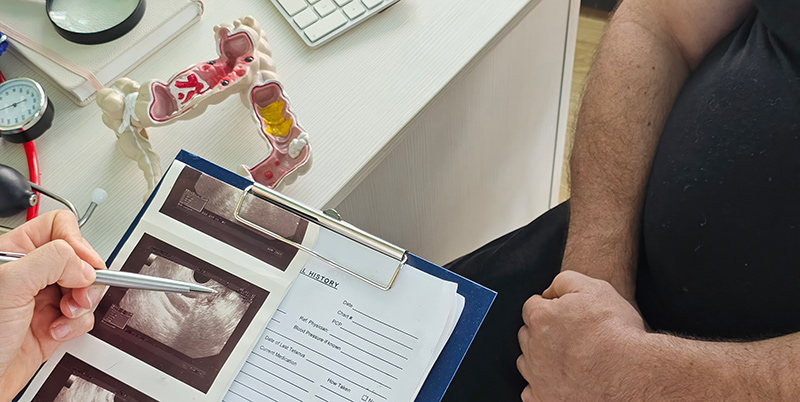 A gastroenterologist reviewing the results of a patient’s assessment